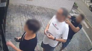 Corrente roubada São Vicente: Registro de vídeo em São Vicente mostra homem caído no chão após ter corrente roubada por adolescente, enquanto outras pessoas aparecem ao redor na calçada.