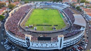 Vista aérea de estádio lotado em Campinas durante o jogo da Ponte Preta, com a Emdec realizando bloqueios de ruas no entorno do estádio Moisés Lucarelli.