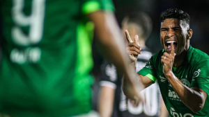 Guarani vence a Inter de Limeira por 3 a 1 e comemora em campo com jogador do time em primeiro plano, celebrando com expressão de gol e torcida ao fundo.