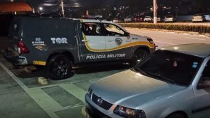vítima encontrada em porta-malas: Vítima de sequestro é encontrada em porta-malas na Rodovia Anhanguera, com viatura da Polícia Militar e carro interceptado à noite em rodovia.