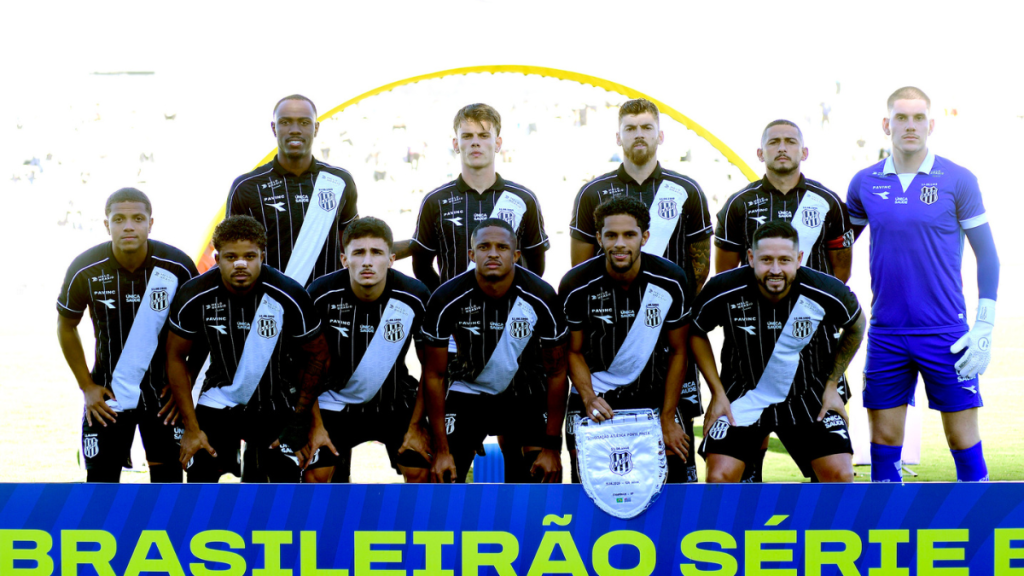 Ponte transfer ban: Elenco da Ponte Preta em foto oficial, com jogadores em campo e escudo do clube ao centro; ao fundo, iluminação do estádio e faixa “Brasileirão Série B”. Foto: Marcos Ribolli.