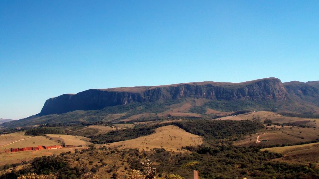rotas do queijo no Brasil: Panorama da Serra da Canastra em paisagem natural com colinas e vegetação do cerrado sob céu azul, destacando o relevo característico da região.