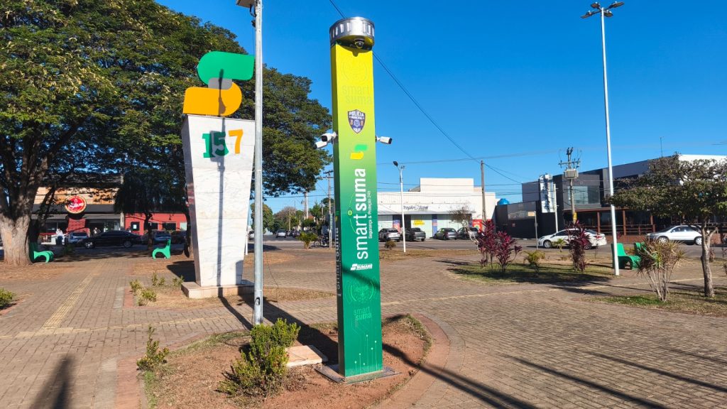 Coluna verde do SmartSuma em área externa com praça e prédios ao fundo, usada para apoiar equipes municipais na identificação de situações suspeitas e planejamento de ações de segurança em Sumaré.