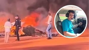 Imagem mostra cenário de emergência e incêndio após queda de avião experimental, com equipes próximas à aeronave e um destaque em círculo de um piloto em cabine com fone de ouvido.