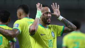 Neto detona Neymar em imagem de jogador da Seleção Brasileira: atleta em campo, camisa amarela e gesto de saudação com as mãos abertas.