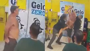 Cena em Mongaguá com homens em ambiente comercial; um homem de terno segura um celular enquanto outro parece estar afastado. Imagem usada para ilustrar matéria sobre barman que matou vendedor ambulante e alegação de legítima defesa.