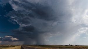 Céu nublado com uma coluna de nuvem e formação em redemoinho em meio a tempestade, ilustrando ciclone furacão tufão tornado e como esses fenômenos são diferentes.