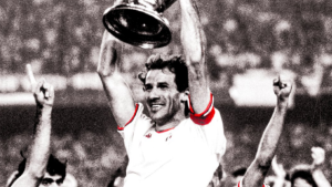 Franco Baresi em imagem histórica do Milan, celebrando com braços erguidos após partida, símbolo de sua carreira como zagueiro em campo.
