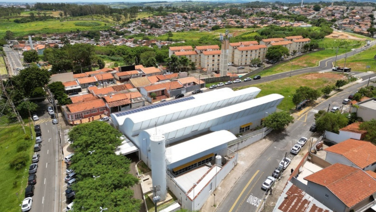 Contratação de médicos em Campinas: Vista aérea de um hospital da Rede Mário Gatti em Campinas, com prédio e estacionamentos ao lado da estrada, divulgando abertura de inscrições para seleção de médicos.