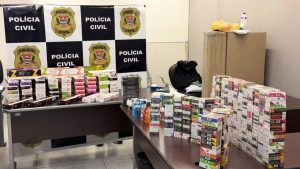 Polícia Civil exibe apreensão de mais de 1,1 mil cigarros eletrônicos em Santa Bárbara, com caixas e dispositivos sobre mesas durante operação.