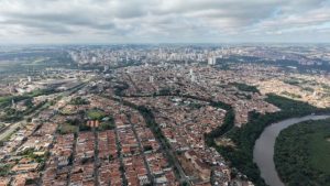 Vista aérea de Piracicaba com bairros e o rio, mostrando a cidade enquanto prepara a Agenda Piracicaba para orientar as ações pelos próximos 10 anos.