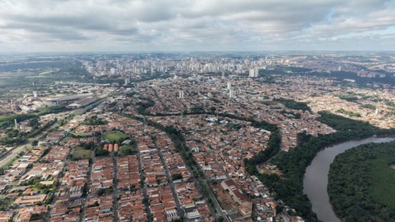 Vista aérea de Piracicaba, mostrando bairros e o rio, enquanto a cidade celebra 259 anos com investimentos, cultura e desenvolvimento ao fundo.