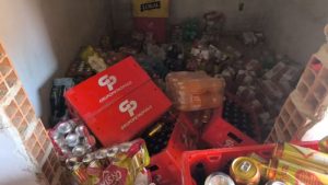 carga de bebidas roubada em Campinas: Carga de bebidas apreendida com caixas e garrafas em um compartimento, recuperada após roubo em Campinas, avaliada em R$ 50 mil.