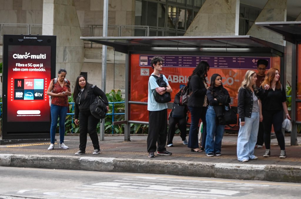 Publicidade de bets Campinas: Placas publicitárias em espaço urbano de Campinas com restrição para propagandas de plataformas de apostas online, mostrando pessoas em frente a painéis publicitários