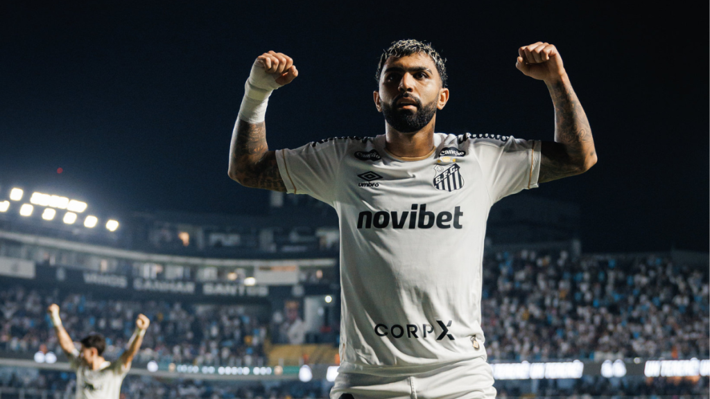 Neymar em campo durante partida com Gabigol comemorando um gol que foi anulado pela arbitragem, em foto do Santos FC com estádio ao fundo. Foto: Raul Baretta.