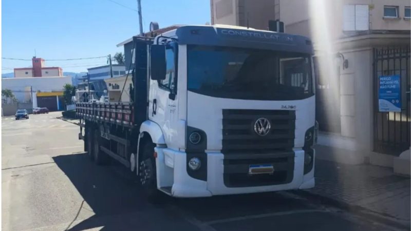 Homem preso com caminhão furtado e placas adulteradas em Atibaia, com caminhão branco estacionado em via urbana durante ação policial.