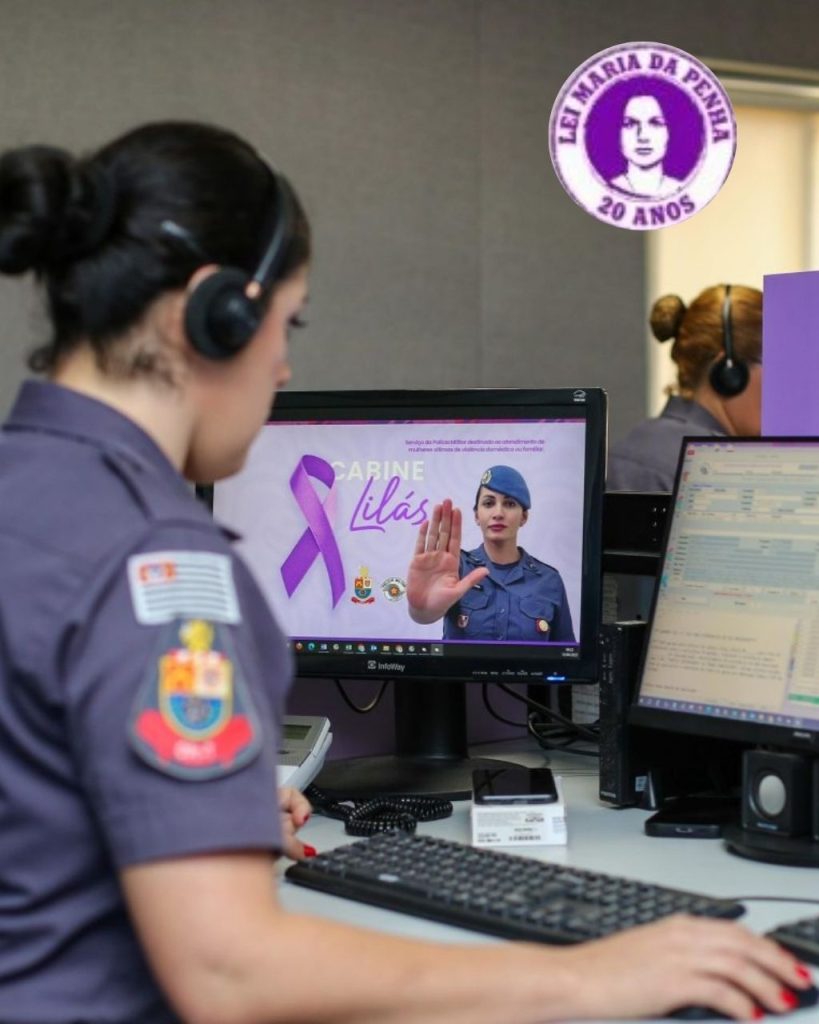 funcionária pública, PM feminina, representando uma possível ocorrência e Agosto Lilás. Representando os 20 anos da Lei Maria da Penha