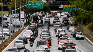 Trânsito intenso na Avenida Paulista em São Paulo, com muitos carros em direção ao Centro e placas de orientação de rotas; cenário urbano típico de impacto por greve.