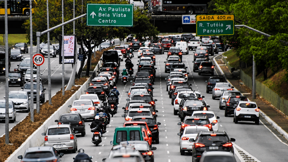 Trânsito intenso na Avenida Paulista em São Paulo, com muitos carros em direção ao Centro e placas de orientação de rotas; cenário urbano típico de impacto por greve.