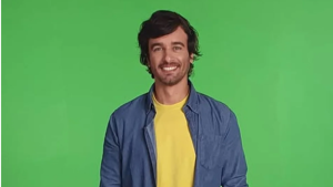 Marco Furlan aparece em imagem de estúdio, sorrindo e usando jaqueta azul sobre camiseta amarela, com fundo verde. Notícia relacionada ao caso.