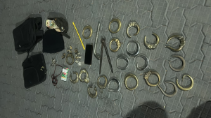 Homem e mulher presos em flagrante: peças e anéis metálicos apreendidos em meio a objetos encontrados em um cemitério, com ferramentas e itens para possível furto de jazigos