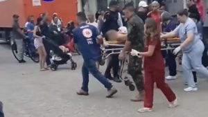 Pai e filho são socorridos após se esfaquearem durante briga em Cubatão, enquanto equipes de resgate conduzem os feridos em meio à movimentação na rua.