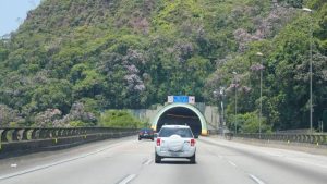 Trânsito em rodovia com túnel ao fundo e veículos seguindo pelo Sistema Anchieta-Imigrantes, em meio a obras que alteram o fluxo; veja cronograma