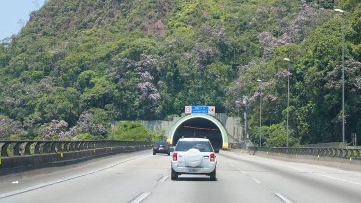 Trânsito em rodovia com túnel ao fundo e veículos seguindo pelo Sistema Anchieta-Imigrantes, em meio a obras que alteram o fluxo; veja cronograma