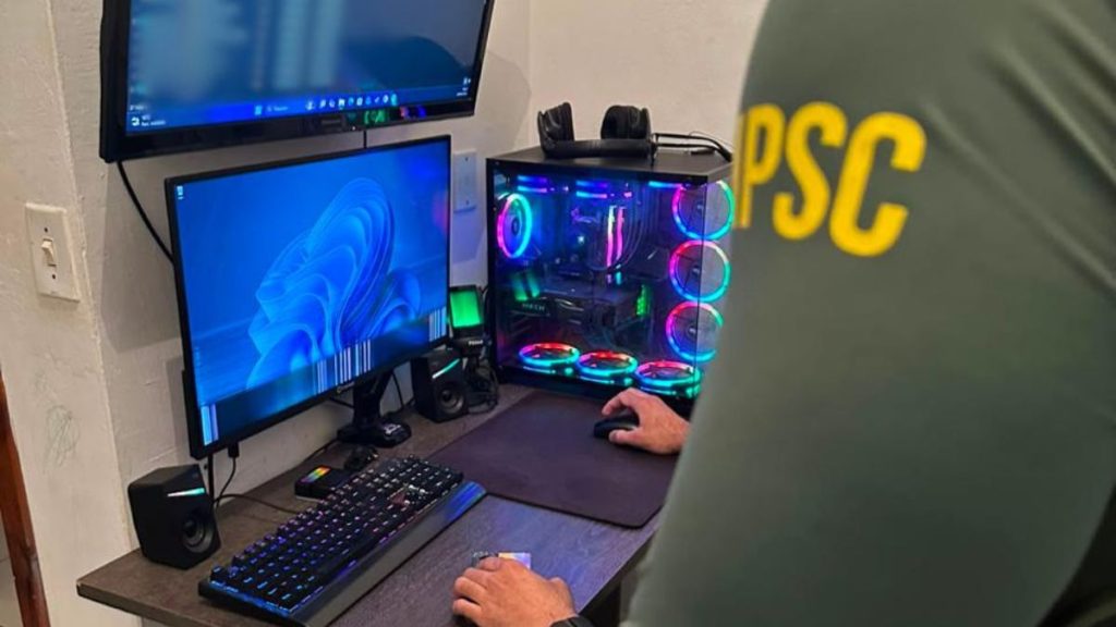 Eleições 2026: imagem de estúdio com computadores e monitores, com pessoa operando um PC em ambiente de debate, mencionando plano de Grupo extremista para usar explosivos