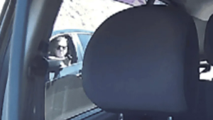 Motorista de app sendo perseguido no trânsito: imagem em close mostra o banco e o vidro do carro, enquanto a cena ao fundo indica uma discussão de trânsito em Americana