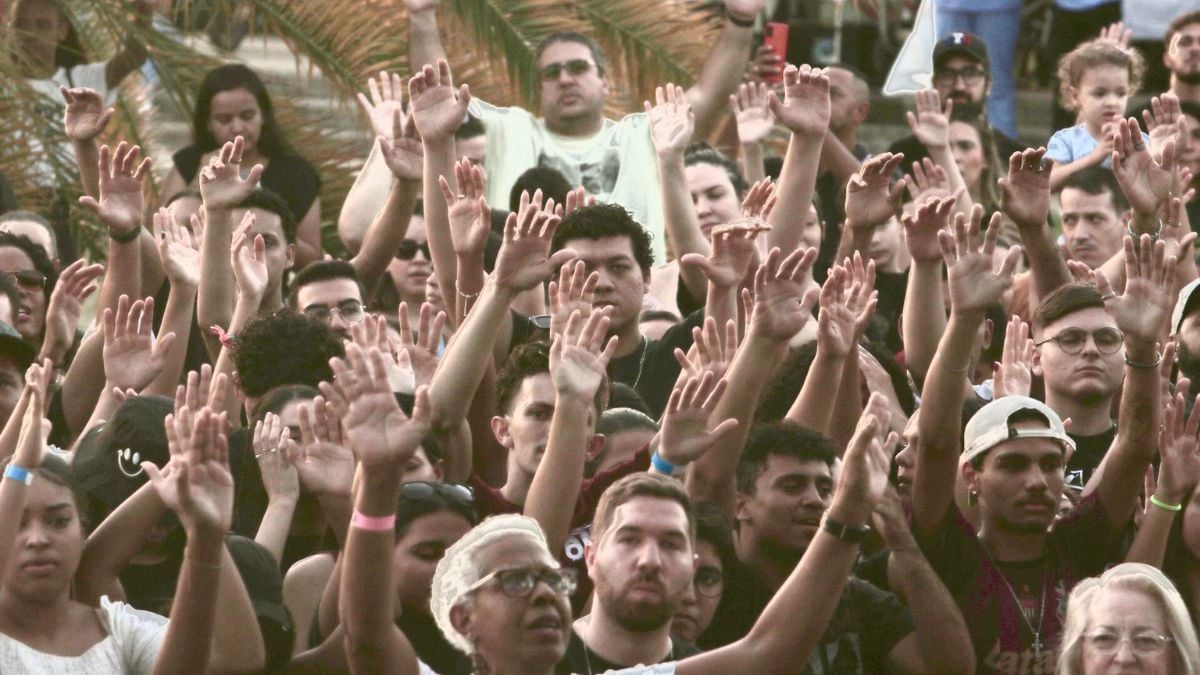 Festival Cultura Gospel em Campinas com FHOP Music, Nesk Only e 3 Palavrinhas: multidão em clima de culto e louvor, com pessoas erguidas e braços levantados ao ar em um evento ao ar livre