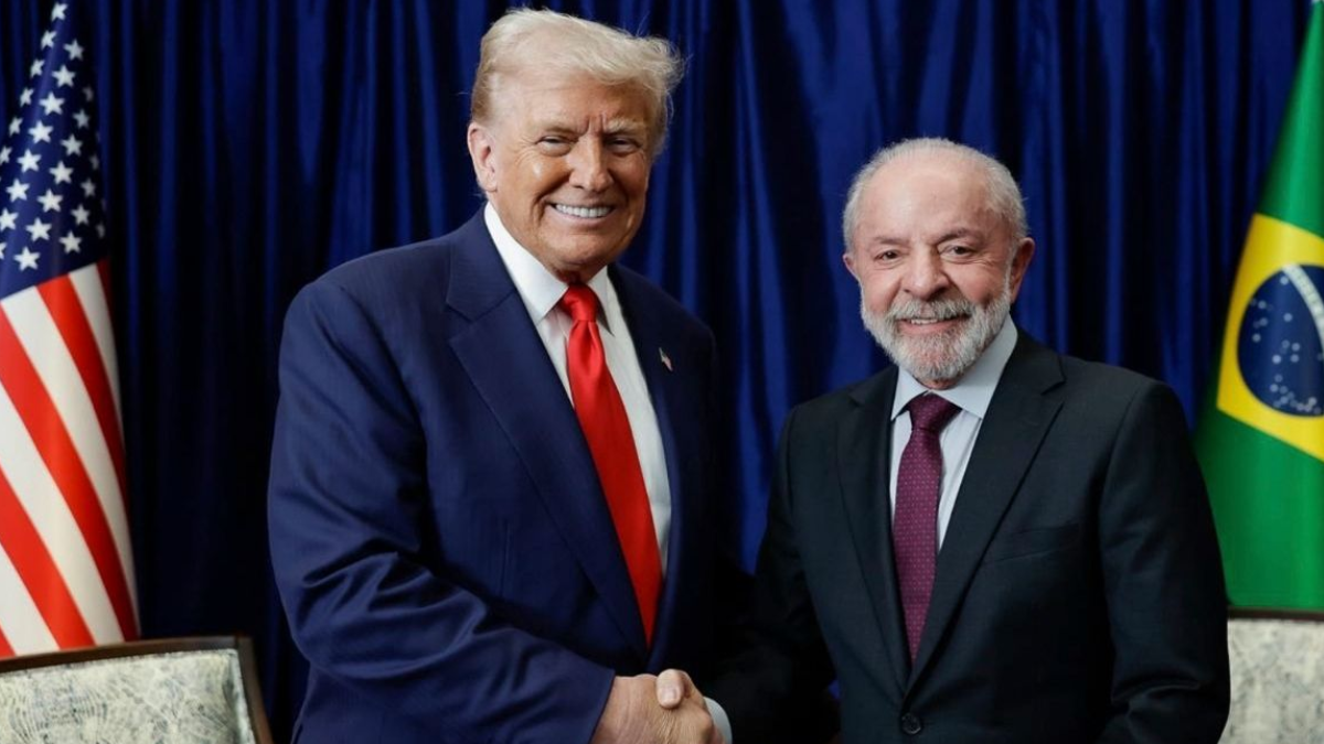 Lula e Trump posam durante encontro com bandeiras do Brasil e dos Estados Unidos ao fundo, em contexto de busca por nova conversa após escalada da crise entre Brasil e EUA.
