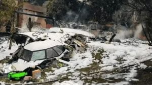 Queda da voepass: imagem de uma aeronave acidentada em meio a destroços e neve, com fumaça ao fundo, ilustrando o cenário do desastre e o laudo da PF.