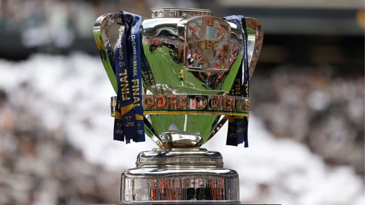 Copa do Brasil: troféu da competição em destaque, com fitas e medalhão refletindo a luz, em meio a um estádio desfocado ao fundo; referência às quartas de final e times classificados.