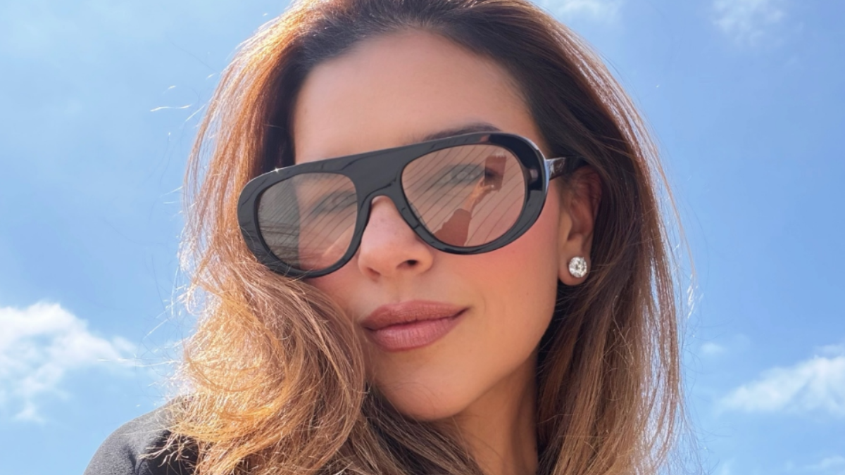Mariana Rios compartilha relato emocionante sobre perda gestacional em uma foto ao ar livre, usando óculos escuros, com céu azul ao fundo.