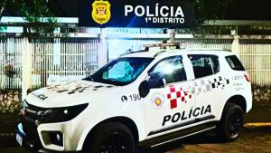 inspetor suspeito de estuprar crianças em Itanhaém: Viatura da Polícia 1º Distrito na área externa durante uma ocorrência, com iluminação noturna e identificação policial na lateral do carro, sugerindo prisão no litoral de SP.