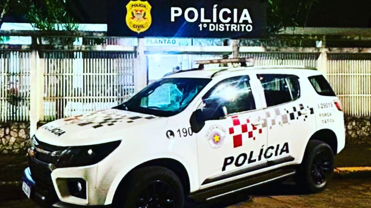 inspetor suspeito de estuprar crianças em Itanhaém: Viatura da Polícia 1º Distrito na área externa durante uma ocorrência, com iluminação noturna e identificação policial na lateral do carro, sugerindo prisão no litoral de SP.