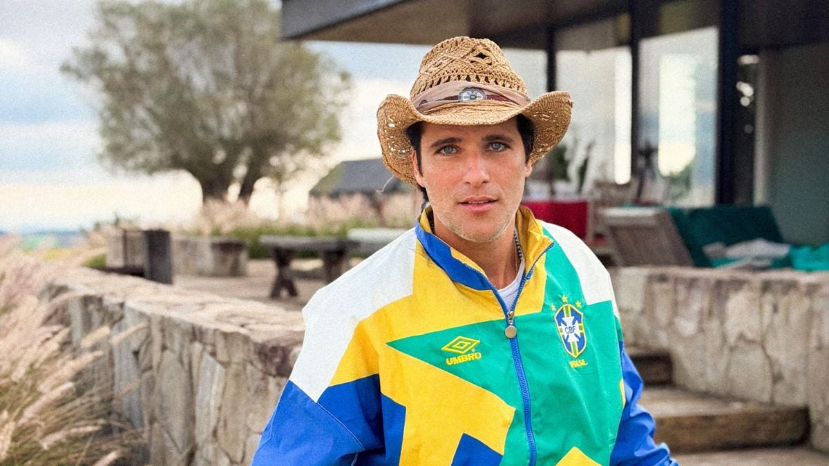Bruno Gagliasso aparece em foto ao ar livre, usando chapéu de palha e jaqueta colorida estilo esportivo, em imagem de repercussão sobre fast-food.
