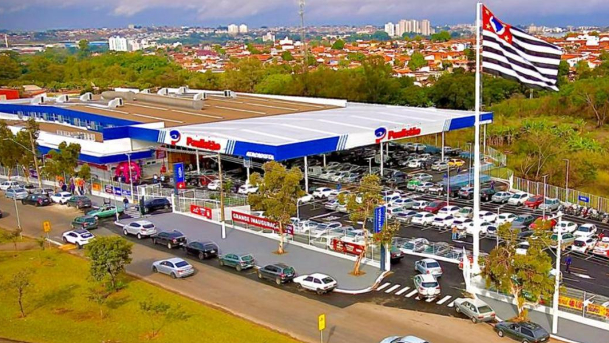 feirão de empregos Paulistão Atacadista: Vista aérea do Paulistão Atacadista em Indaiatuba, com estacionamento amplo e veículos, destacando 150 vagas para contratação imediata no feirão de empregos.