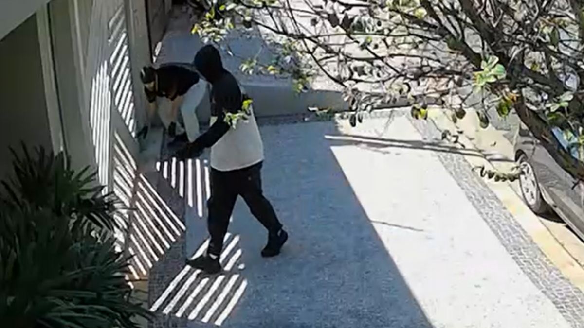 Suspeita de furto a residência em Pedreira: dois homens são vistos na entrada de uma casa, em imagem de câmera de segurança durante uma perseguição, com portão e corredor ao fundo.