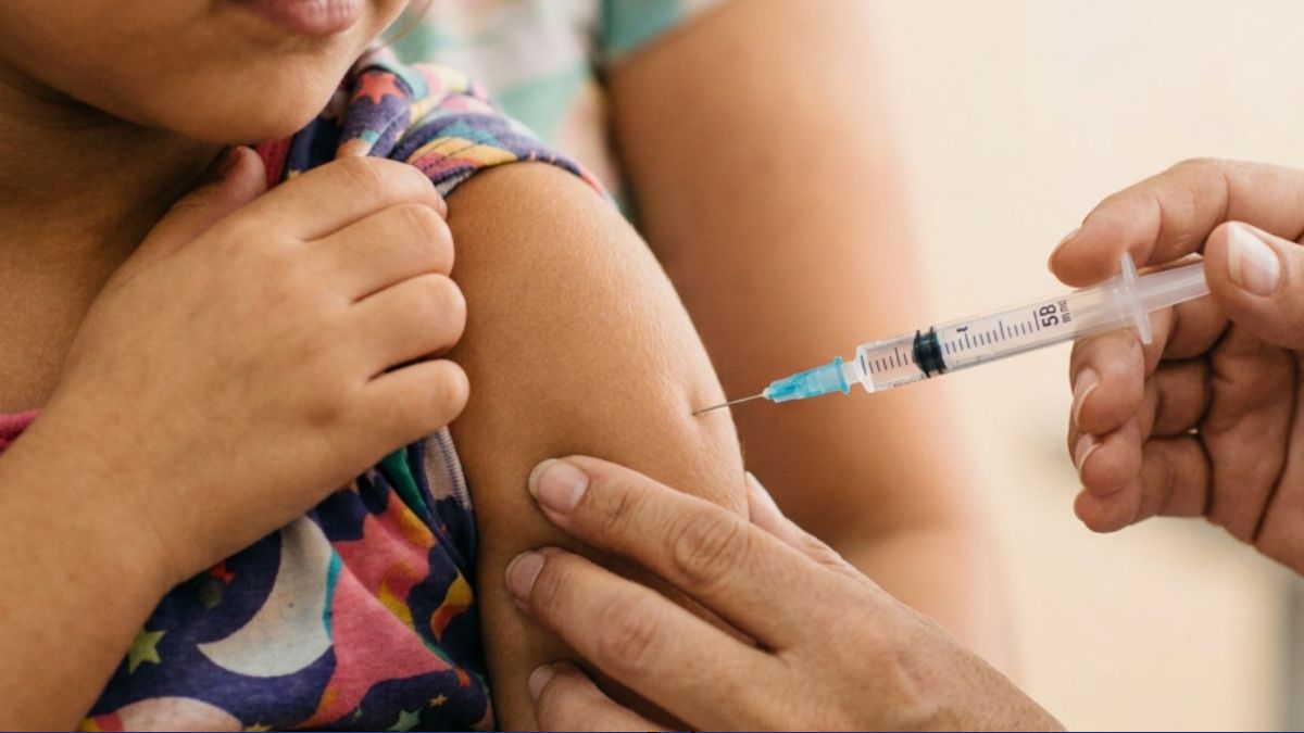 Vacinação em Atibaia: profissional aplica injeção na pele do braço de uma criança, durante atualização vacinal de crianças e adolescentes.