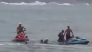 Resgate mulher afogamento Guarujá: guarda-vidas entra no mar e salva uma mulher, enquanto uma moto aquática ajuda na operação de socorro na praia do Guarujá.