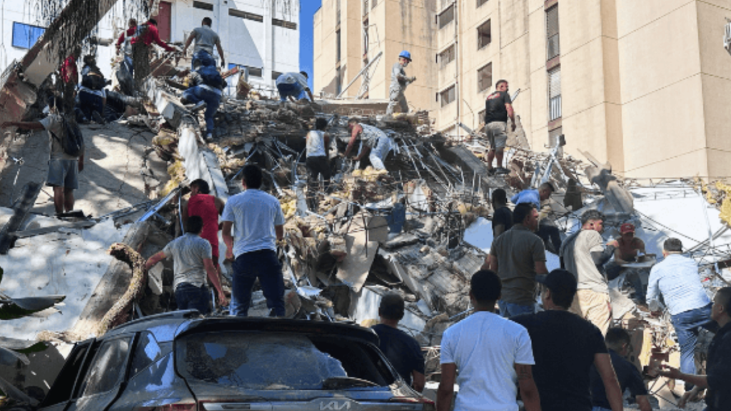 Terremoto na Colômbia: equipes e moradores caminham entre escombros e prédios danificados após a tragédia, enquanto buscas continuam no segundo dia.