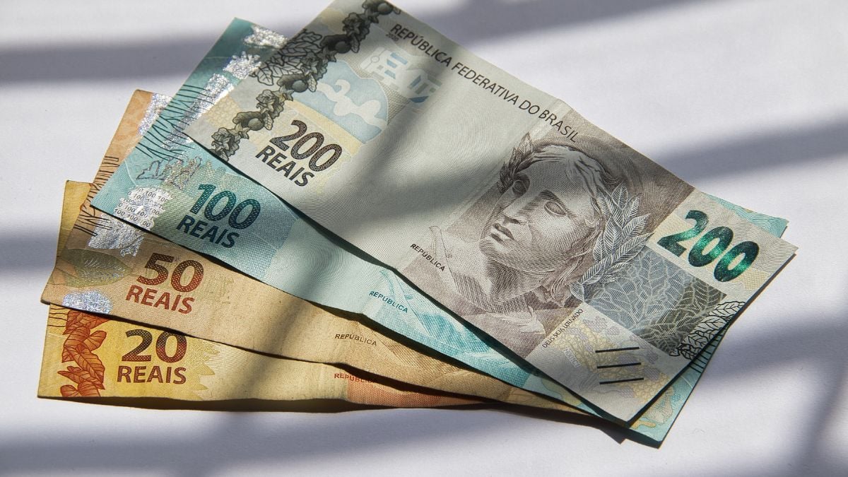 Dinheiro esquecido: cédulas de reais brasileiras sobre fundo claro, sugerindo que valores esquecidos ainda podem ser sacados nos bancos