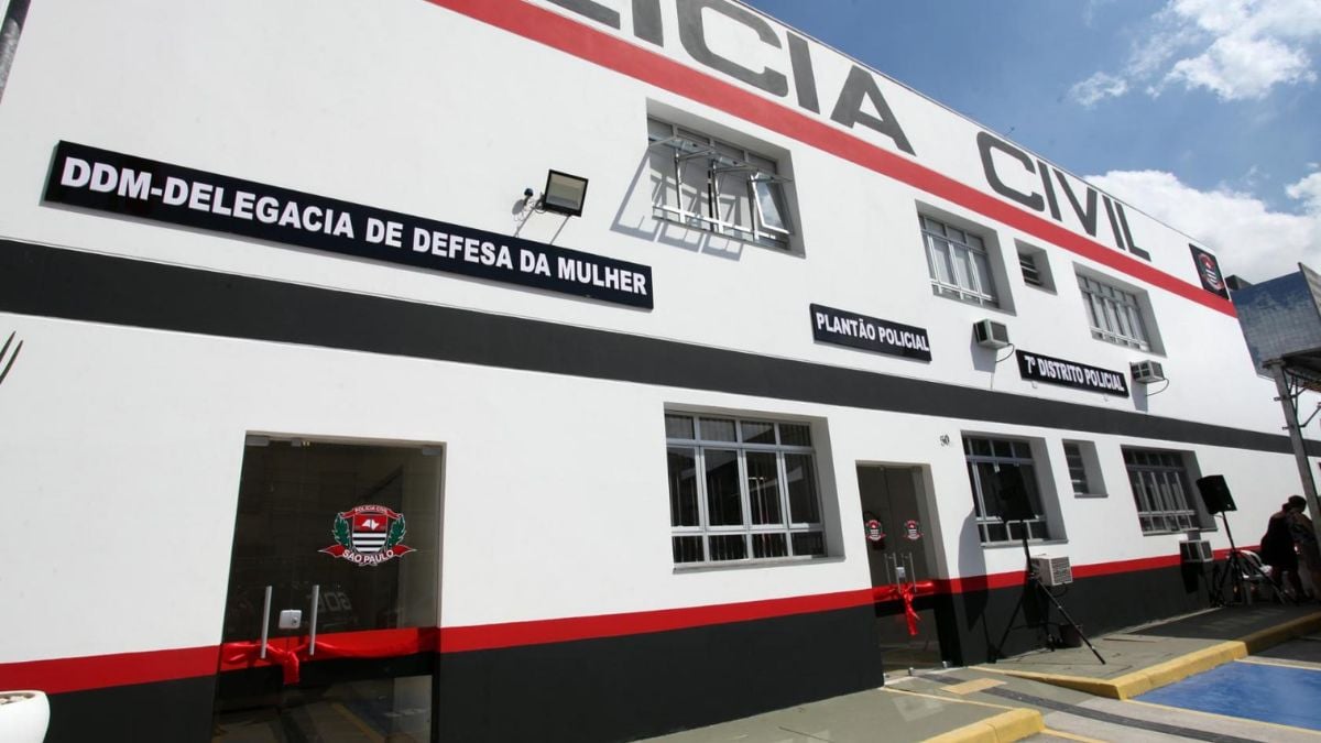 Fachada de um prédio oficial com a placa “DDM-Delegacia de Defesa da Mulher” e “CET-Santos CIVIL”, em reportagem sobre CET-Santos agressão e acusação de agredir ex-namorada com tapas no rosto.