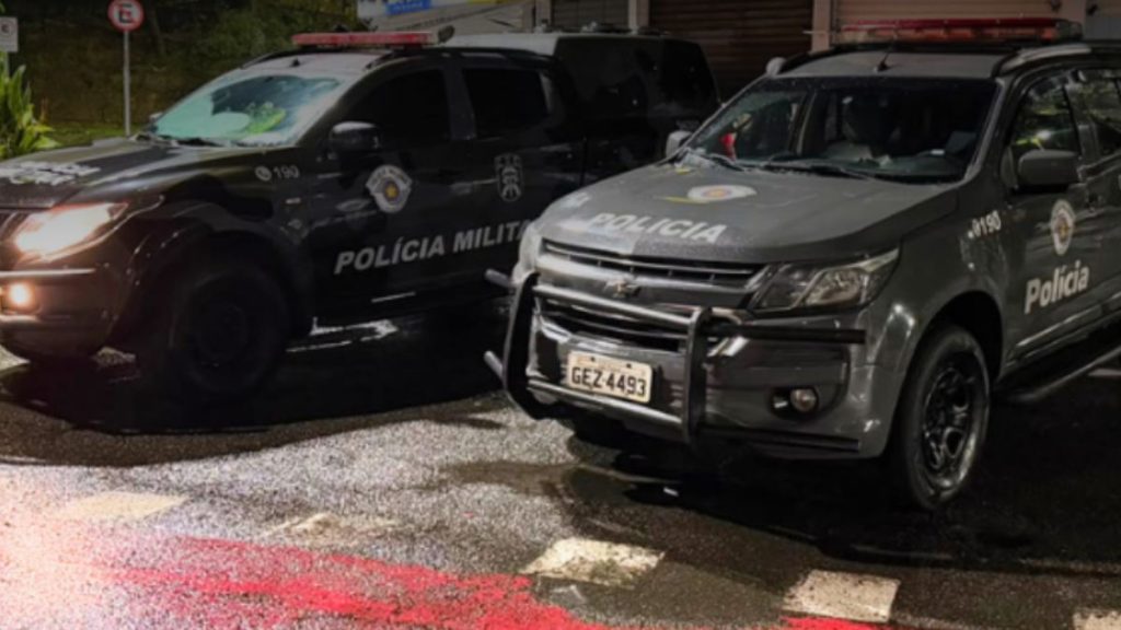 Suspeito de sequestro e tortura de advogado: Viaturas da Polícia Militar em operação no endereço de ação do GAECO, com carros policiais estacionados à noite em São Paulo, contra grupo suspeito de sequestrar e torturar advogado