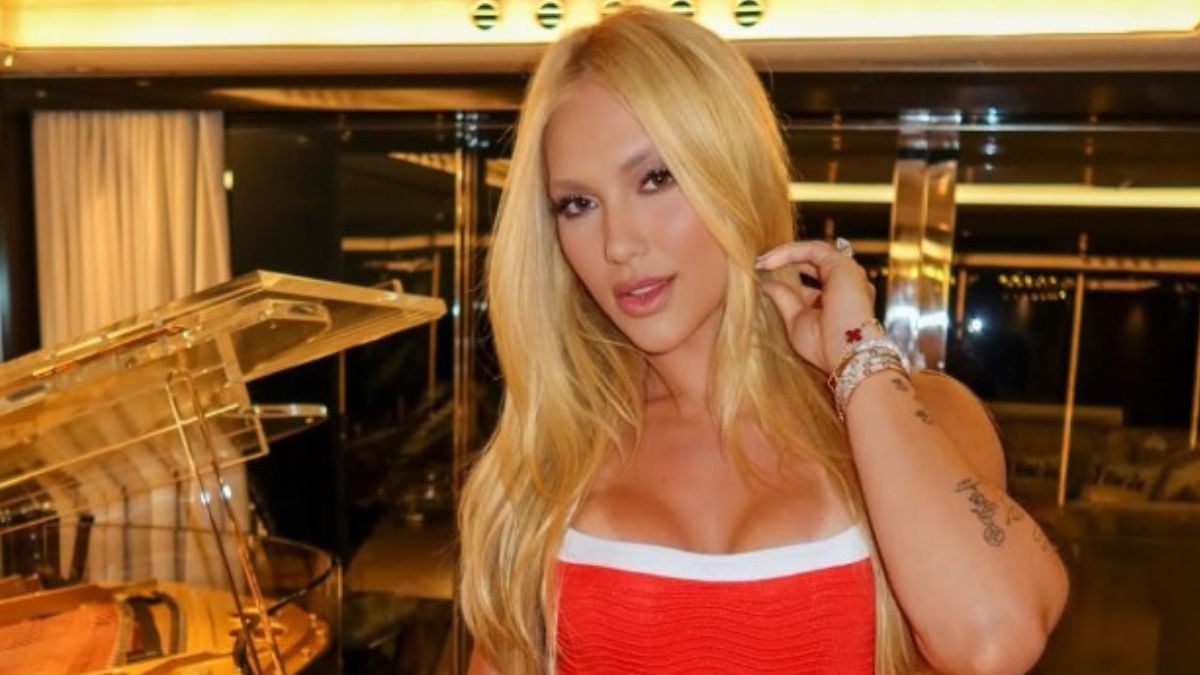 Virginia Fonseca exibe resultado de harmonização nos glúteos após procedimento, em foto com cabelo longo loiro e vestido vermelho em ambiente interno iluminado