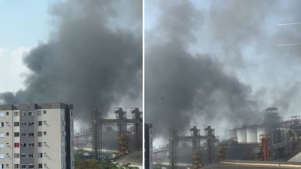 Caminhão Santos envolvido em incêndio após carregar piche, com fumaça densa e cenário industrial em Santos; registros mostram grande coluna de fumaça.