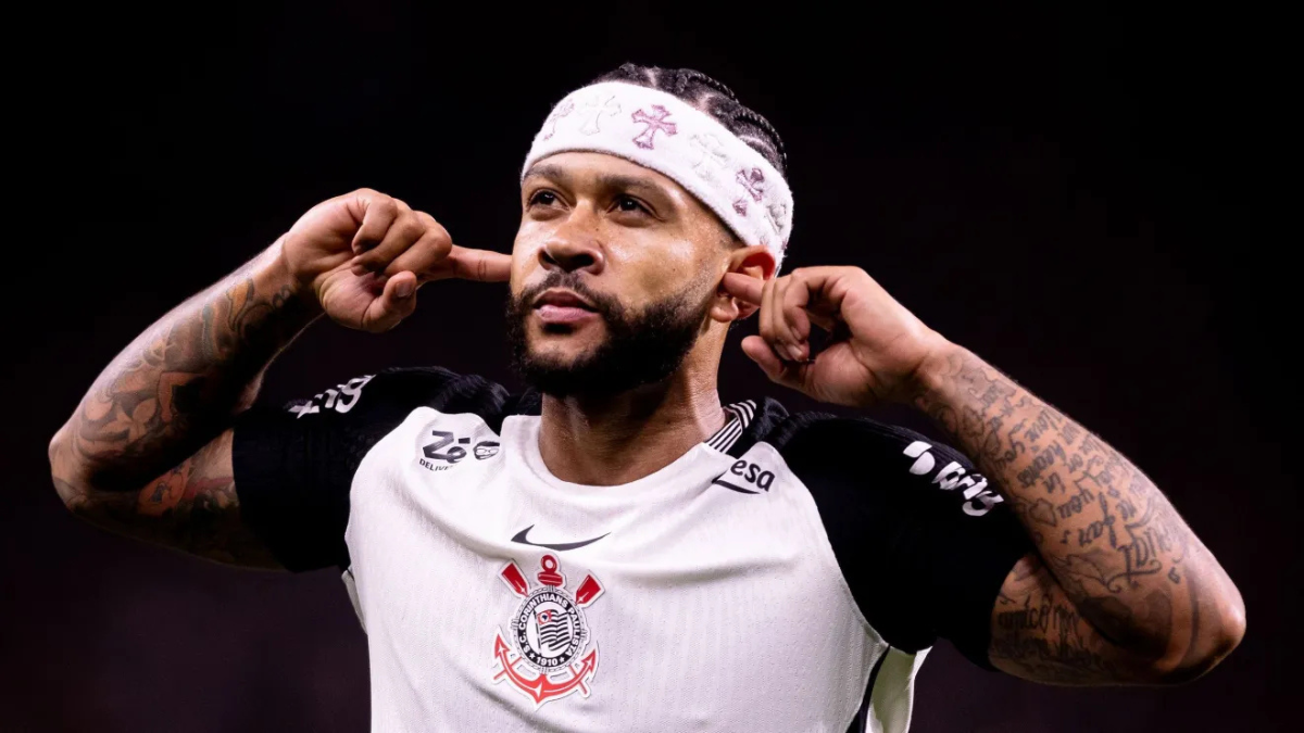 Memphis em foto de jogo do Corinthians, com faixa de cabeça e uniforme branco, fazendo pose com as mãos, com visão de futuro do jogador destacada em chamada de texto