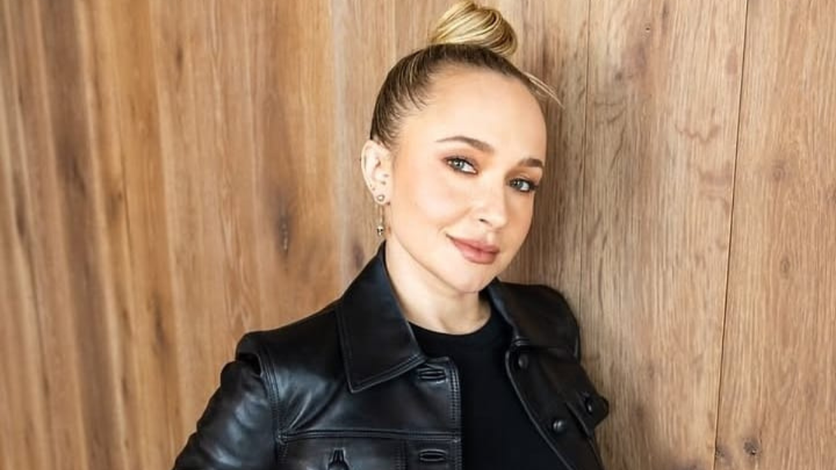 Hayden Panettiere, atriz de ‘Heroes’, aparece em foto de evento com visual de couro preto, cabelos presos e fundo de madeira; notícia sobre morte aos 36 anos e caso investigado.